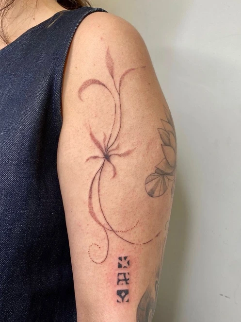 Diseño botánico de líneas rojizas sobre el brazo