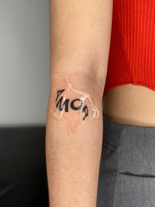 Tatuaje de letras negras sobre el brazo